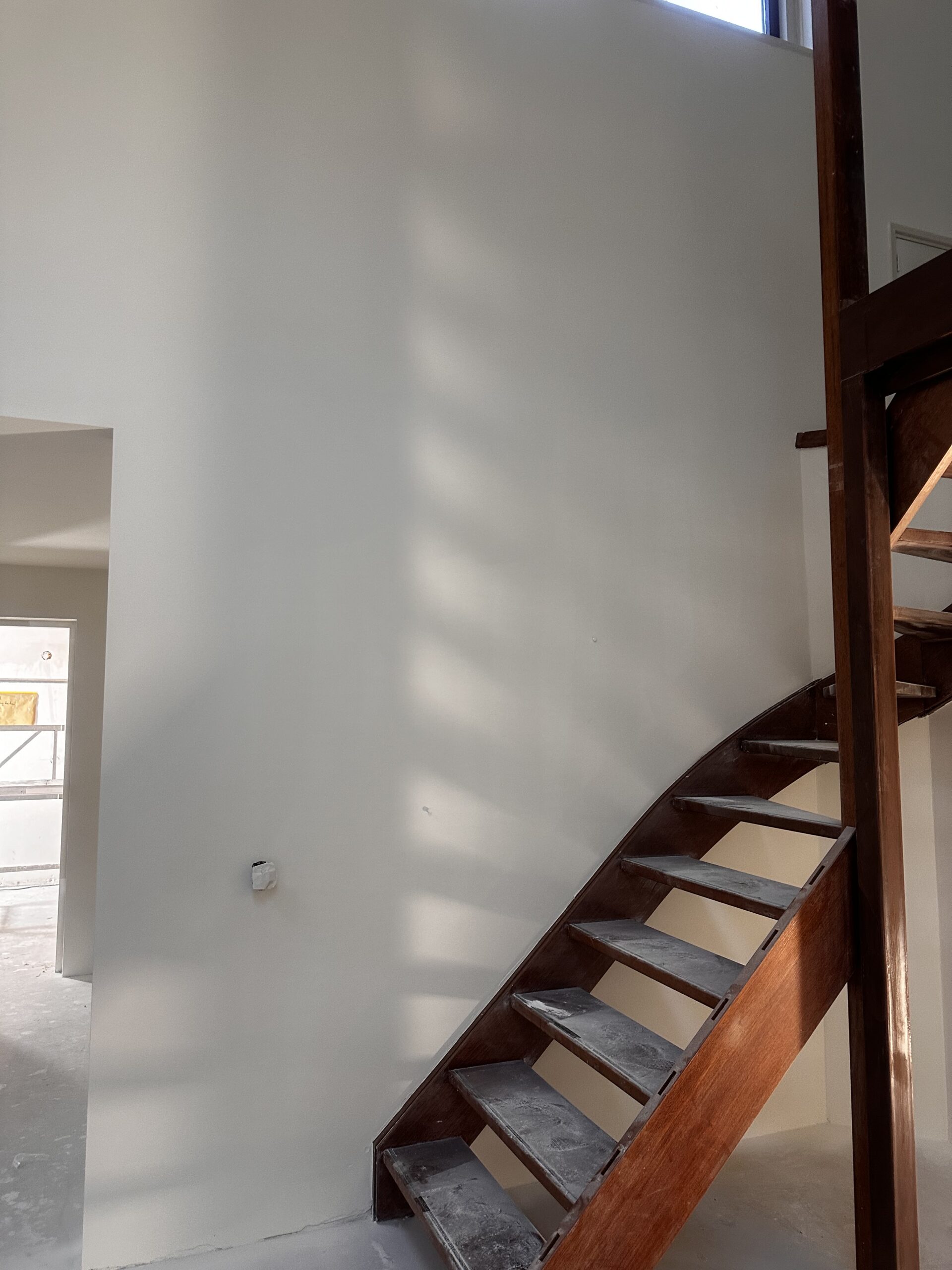Hoge wand strak latex gespoten Hoge wand naast een trap professioneel afgewerkt met latex spuitwerk.