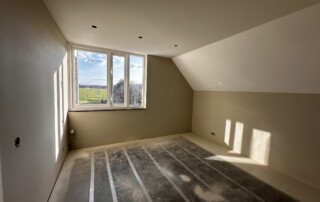 Slaapkamer met strak gespoten wanden en plafond voor een moderne afwerking.